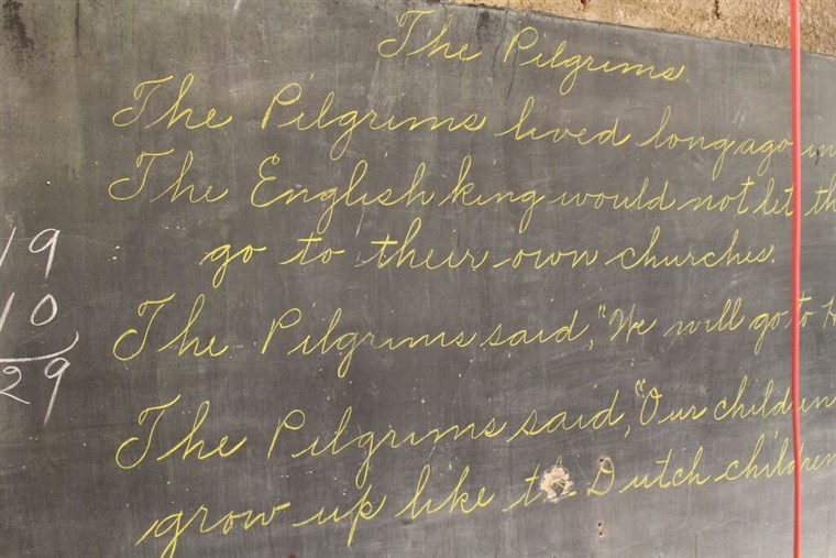 واحد chalkboard featured a teacher's beautiful cursive writing.