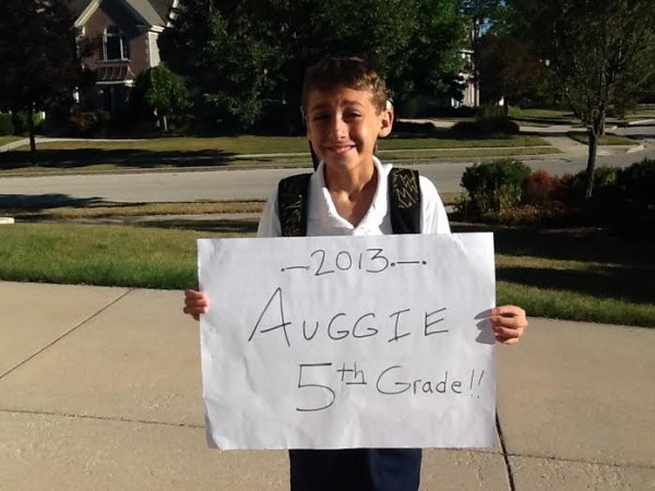 صبي holding fifth-grade sign