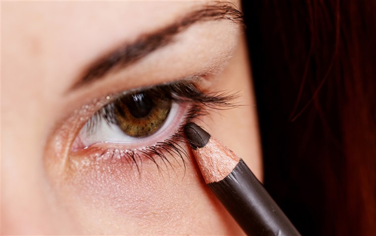 Frau applying eyeliner