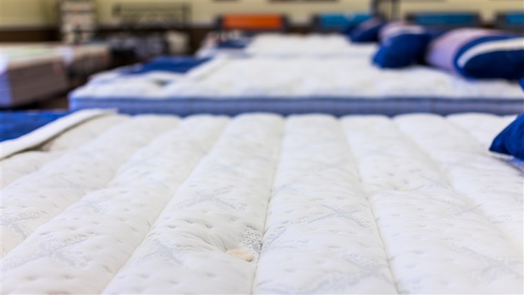 قريب of many mattresses on display in store