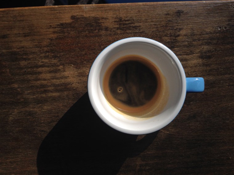 Nalévat espresso into a large coffee cup
