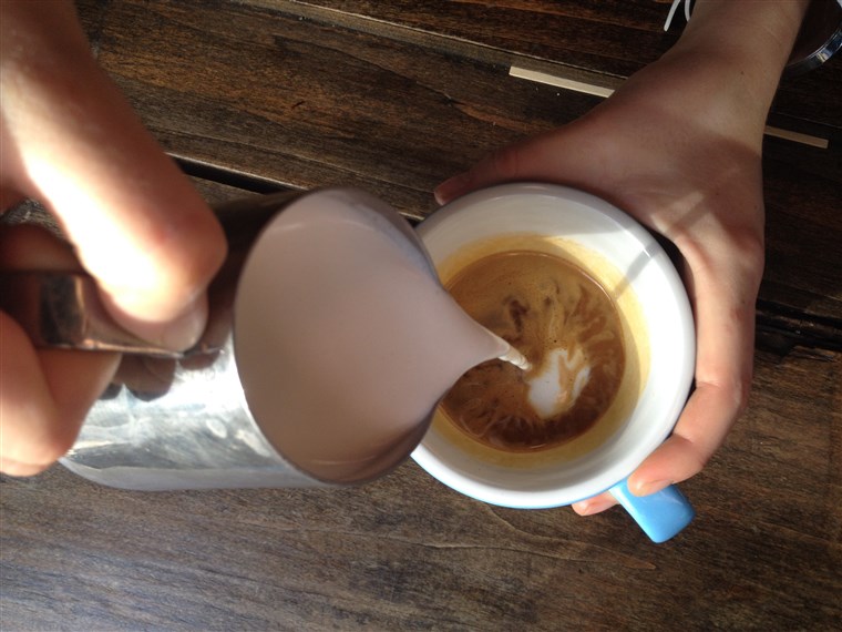 Nalévat a dollop of steamed milk into espresso