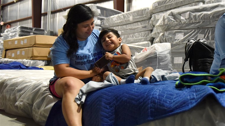 Lopez plays with her son in the warehouse at Gallery Furniture in Houston