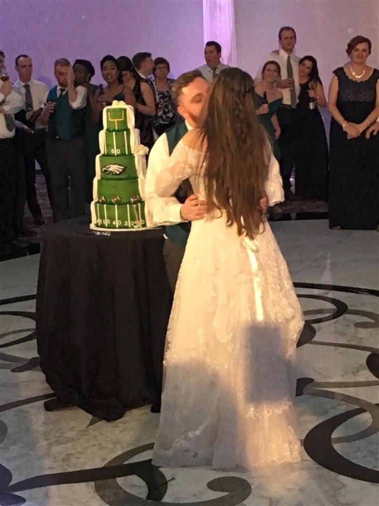 А couple whose wedding cake was traditional on one side, Philadelphia Eagles themed on the othe