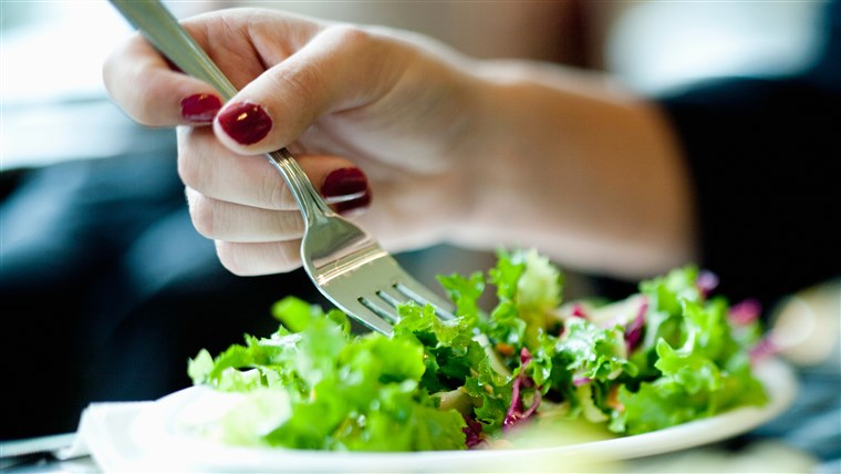 Nahansicht of woman's hand eating salad