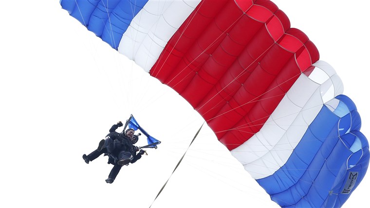 Ehemalige President George H.W. Bush, strapped to Sgt. 1st Class Mike Elliott, a retired member of the Army's Golden Knights parachute team, floats to the ground during a tandem parachute jump near Bush's summer home in Kennebunkport, Maine, on Thursday in celebration of his 90th birthday. 