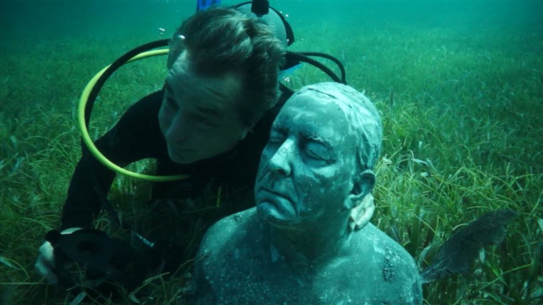 图片： Kerry Sanders poses under water with his sculpture