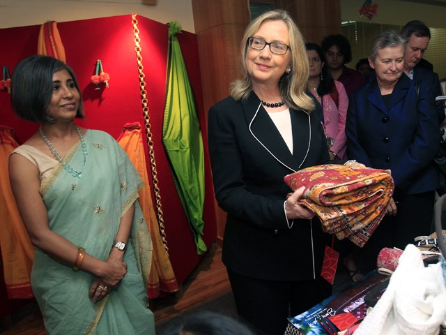 她 might be going easy on the makeup, but she still has an eye for colorful fashion: Clinton holds a sari in Kolkata, India, on May 6.
