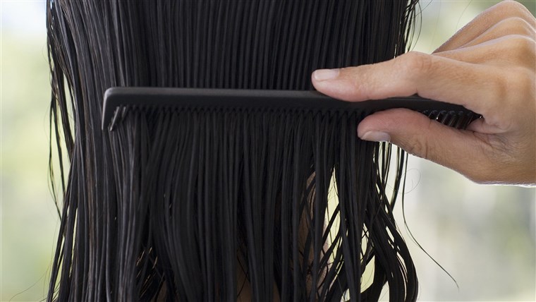 女人 combing hair, rear view